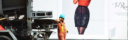 Construction worker in front of boutique sign